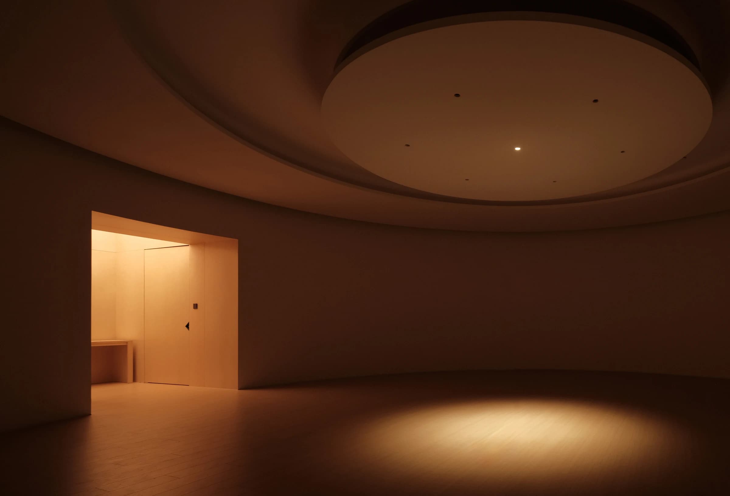 Dramatic circular ceiling with recessed spotlights creating warm ambient glow in gallery space