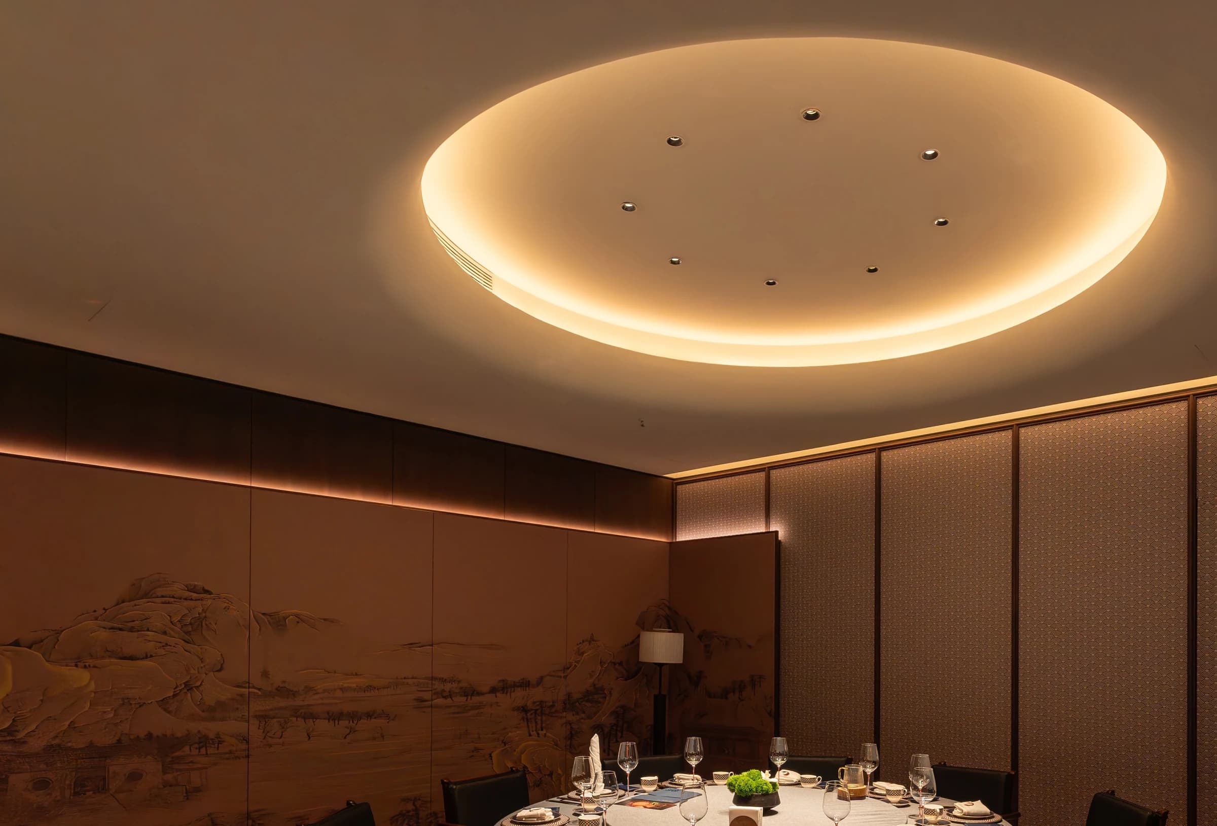 Private dining room with illuminated circular ceiling feature and formal table setting