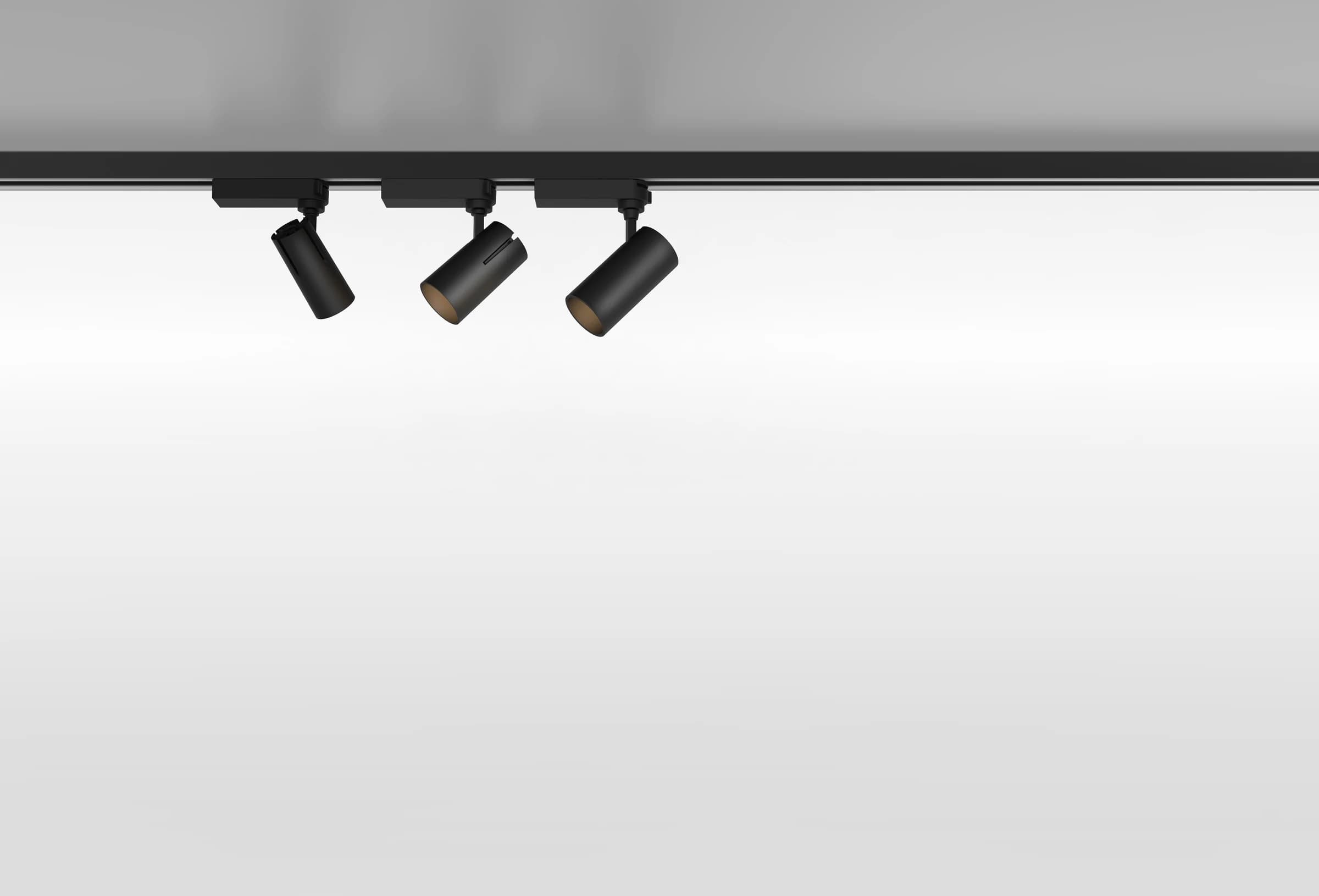 Three ceiling-mounted disc fixtures with warm ambient uplight, low angle view